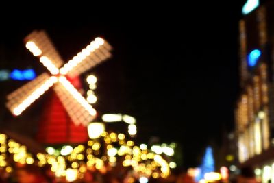 Low angle view of illuminated christmas lights against building at night