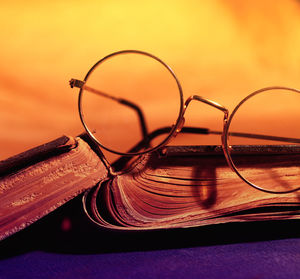 Close-up of old eyeglasses with book on table