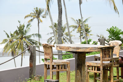 Close-up of chair on table by sea against sky