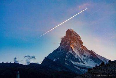 Low angle view of snowcapped mountains against sky