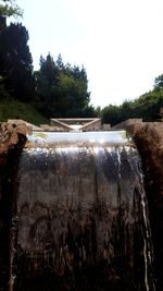 Close-up of water flowing through rocks against clear sky