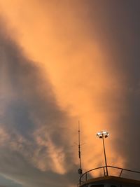 Low angle view of silhouette communications tower against sky during sunset