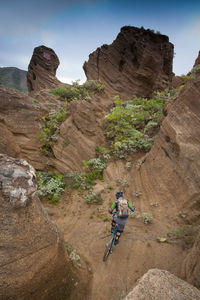 Man skiing on rocky mountain against sky