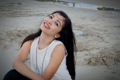 Portrait of beautiful woman sitting at beach