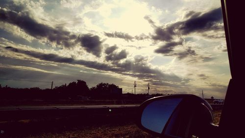 View of road against cloudy sky at sunset