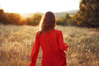 Rear view of woman standing on field