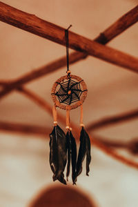 Dreamcatcher with black feathers hanging in boho beige interior. magical and ritual ornament