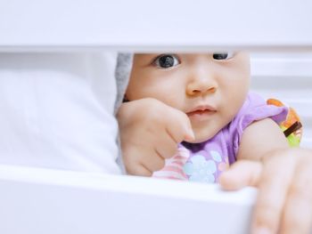 Close-up of cute baby on bed at home