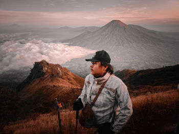 Man standing on mountain against sky