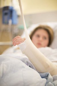 Girl with broken arm in hospital bed