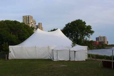 Tent on field by building against sky