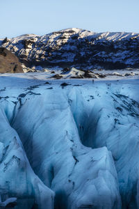 Lone hiker stands on the sólheimajökull glacier in the katla geopark