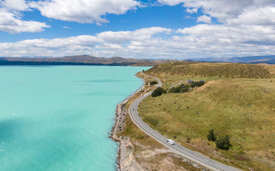 Aerial view of road by lake against sky