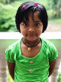 Close-up portrait of girl standing by balustrade