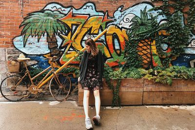 Man standing by graffiti wall