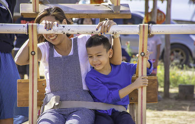 Woman and boy sitting on ferris wheel