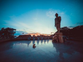 Buddha statue against sky during sunset