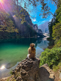 Female traveler on the shore of a mountain lake