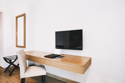 Empty chairs and table against wall at home