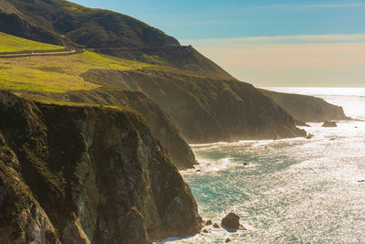 Scenic view of sea and mountains against sky