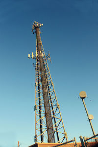 Low angle view of crane against clear blue sky