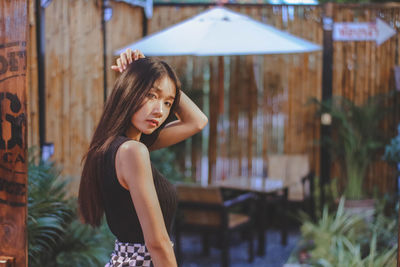 Side view portrait of young woman standing at restaurant