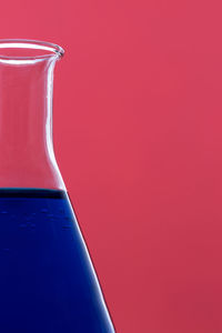 Close-up of glass against red background