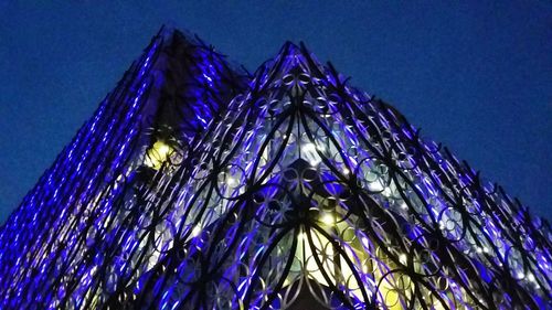 Low angle view of illuminated lights against clear blue sky