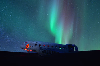 Northern lights over plane wreckage in iceland.old crashed military 