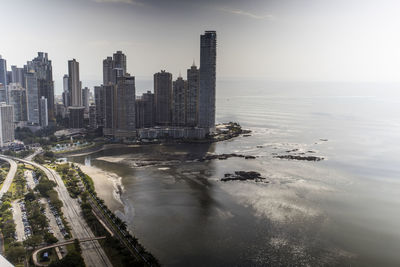 High angle view of city by sea against sky