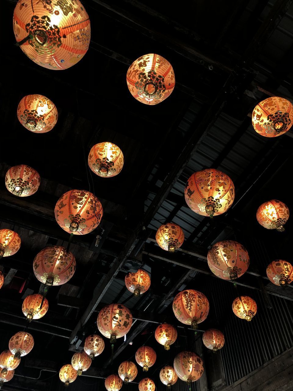 LOW ANGLE VIEW OF ILLUMINATED LIGHTING EQUIPMENT HANGING AT CEILING