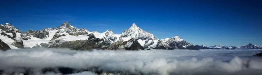 Scenic view of snow covered mountains against sky
