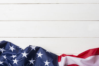 Low angle view of flags hanging against white wall