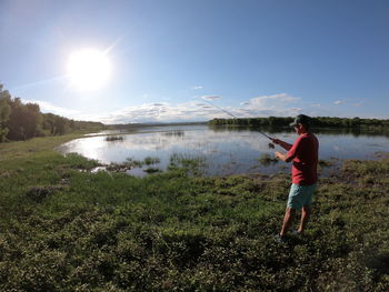 Woman standing on lake against sky