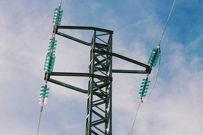 Low angle view of electricity pylon against sky