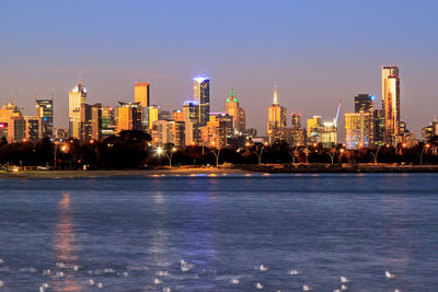 Illuminated buildings in city against sky