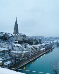 High angle view of buildings by river against sky