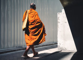 Rear view of woman standing against wall
