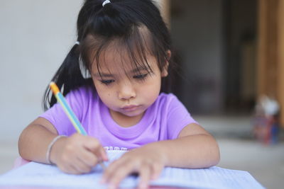 Portrait of cute girl sitting on table