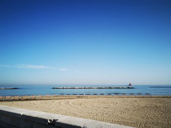 Scenic view of beach against blue sky