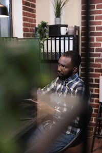 Man writing on clipboard sitting in office