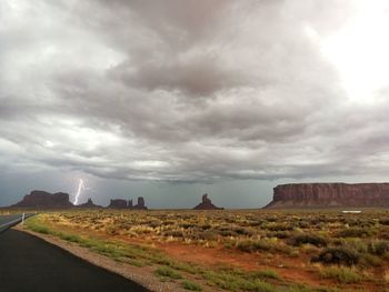 Scenic view of desert against storm clouds