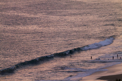 High angle view of waves reaching towards shore during sunset