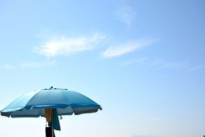 Low angle view of umbrella against blue sky