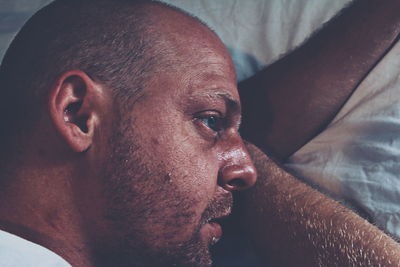 Directly above shot of thoughtful man lying on bed