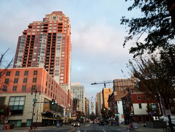 View of city street and buildings against sky