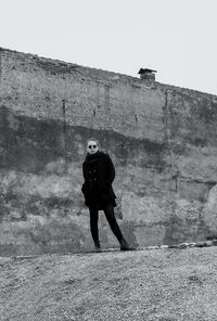 Full length of woman standing against wall