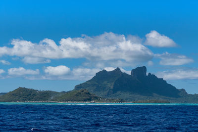 Scenic view of sea and mountains against sky