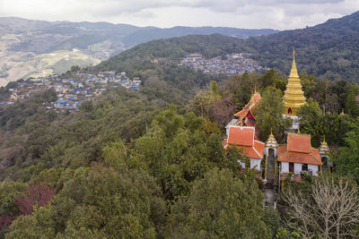 Panoramic view of trees and buildings against mountains