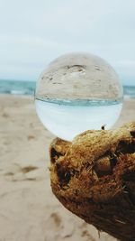 Close-up of crystal ball with beach reflection